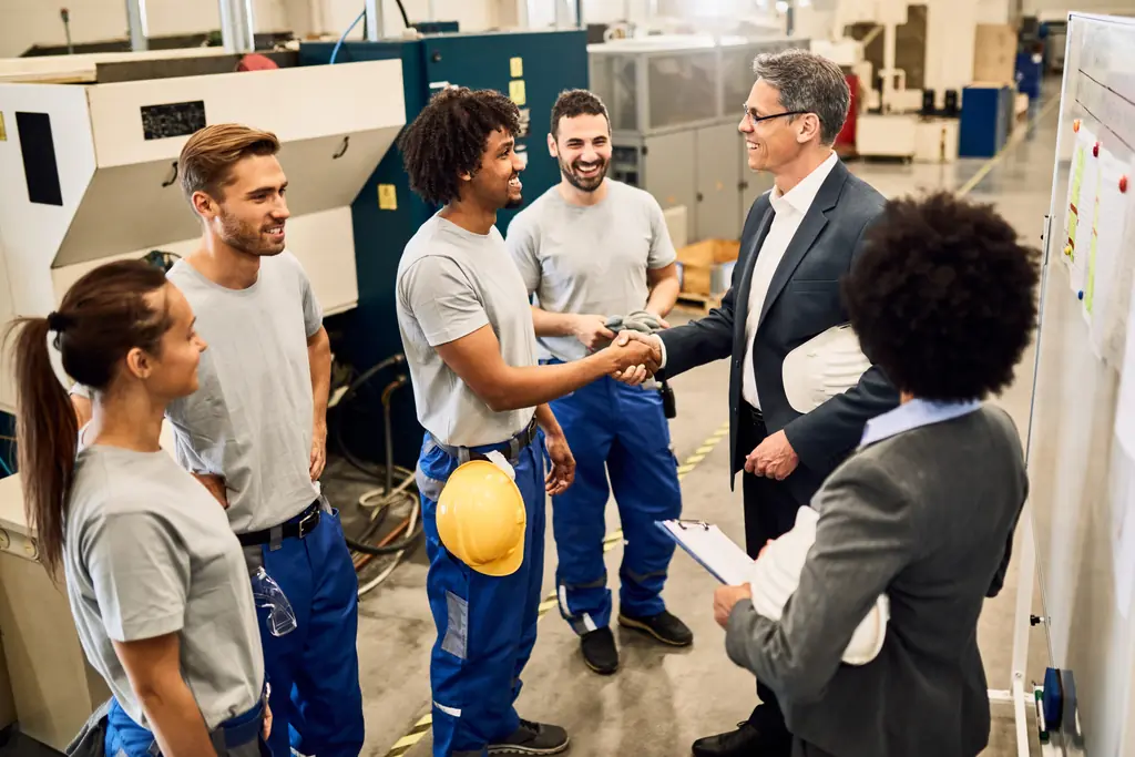 Responsable d'entreprise industrielle accueillant un collaborateur en atelier