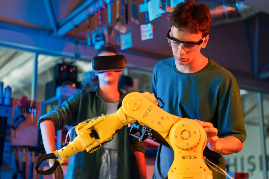 Jeunes apprentis manipulant un bras robotisé