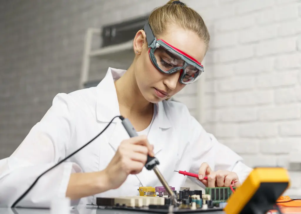 Apprentie concentrée sur un travail de précision en électronique